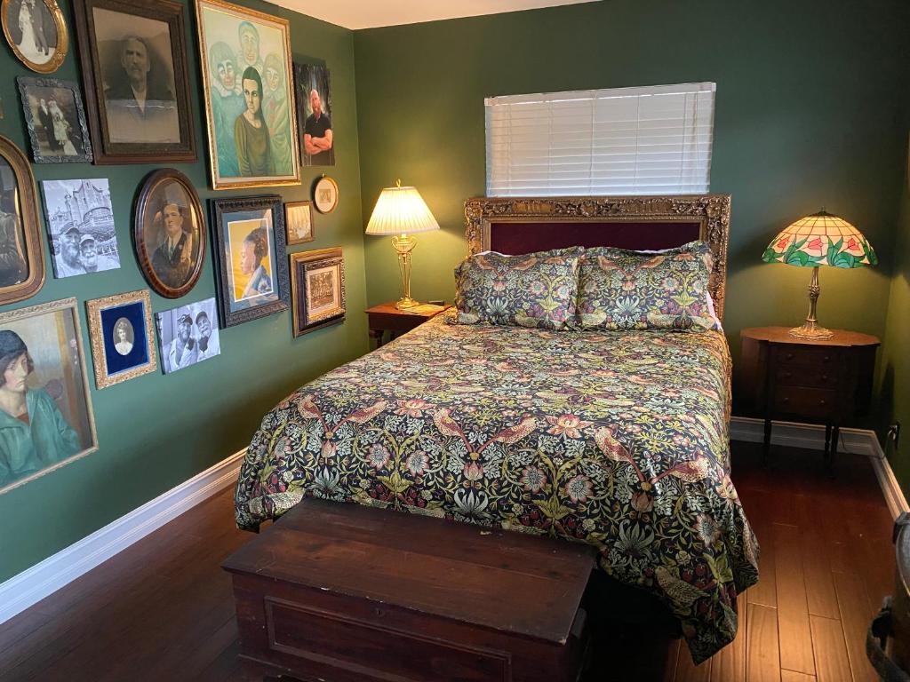 a bedroom with a bed and pictures on the walls at Phantom History House - Portrait Room in Tampa