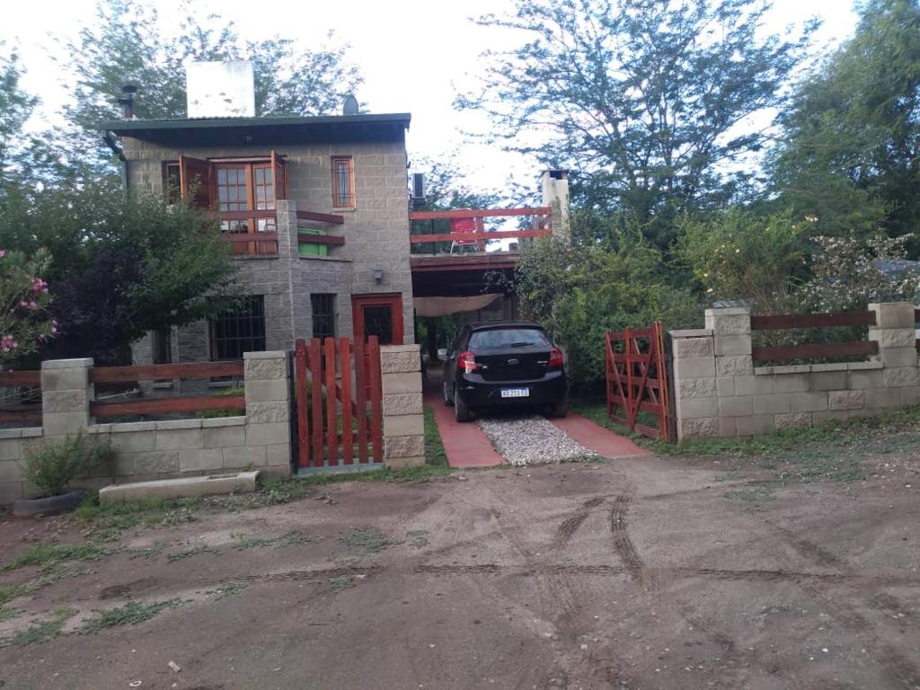 un coche aparcado frente a una casa con una puerta en Cabaña en las sierras de Cosquín en Cosquín