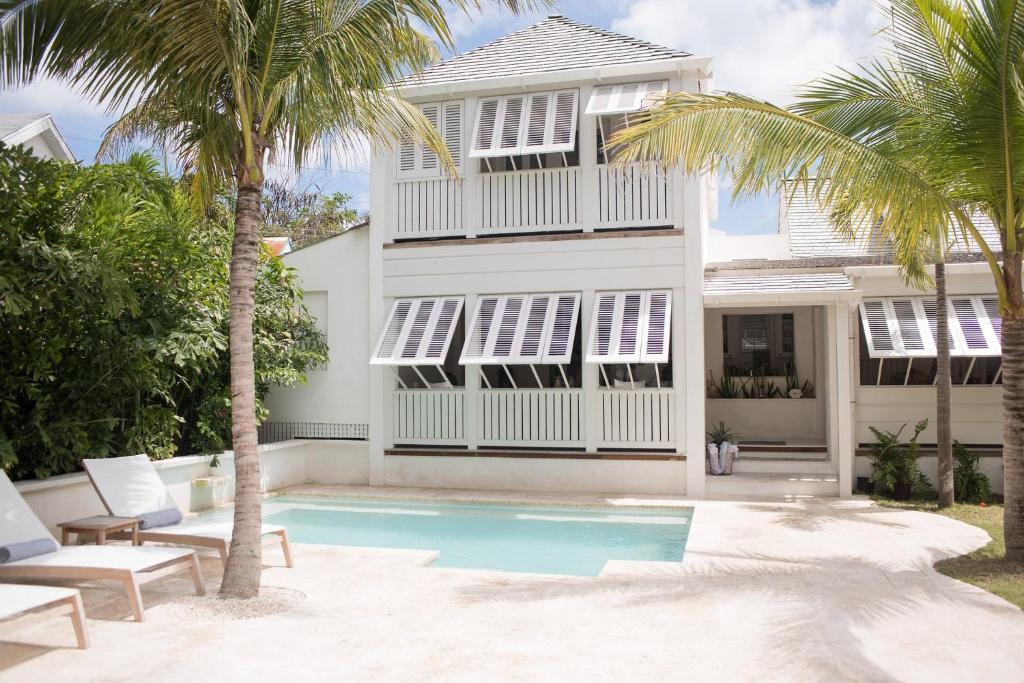 a house with a swimming pool and palm trees at Conch Shell Harbour Island home in Harbour Island