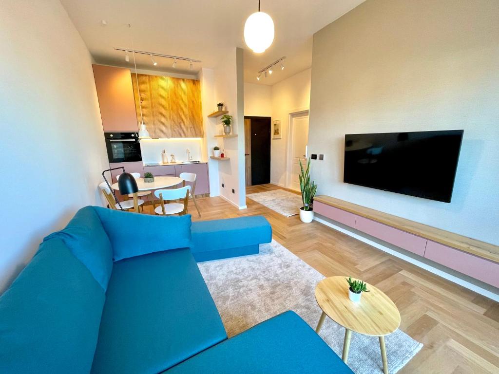 普里什蒂納的住宿－Floral Inn，客厅配有蓝色的沙发和平面电视。