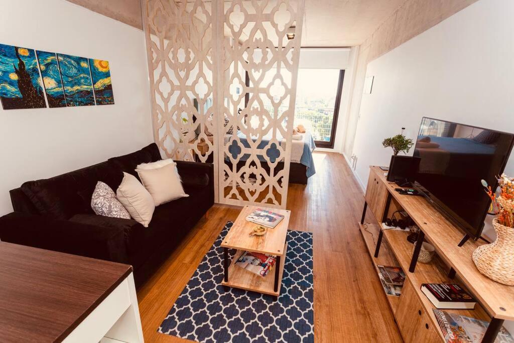 sala de estar con sofá y mesa en Moderno piso en San Telmo con vistas a la ciudad en Buenos Aires