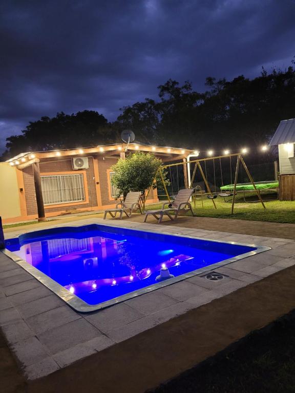 una piscina con luces azules en un patio trasero por la noche en Cabaña Solares en La Silleta