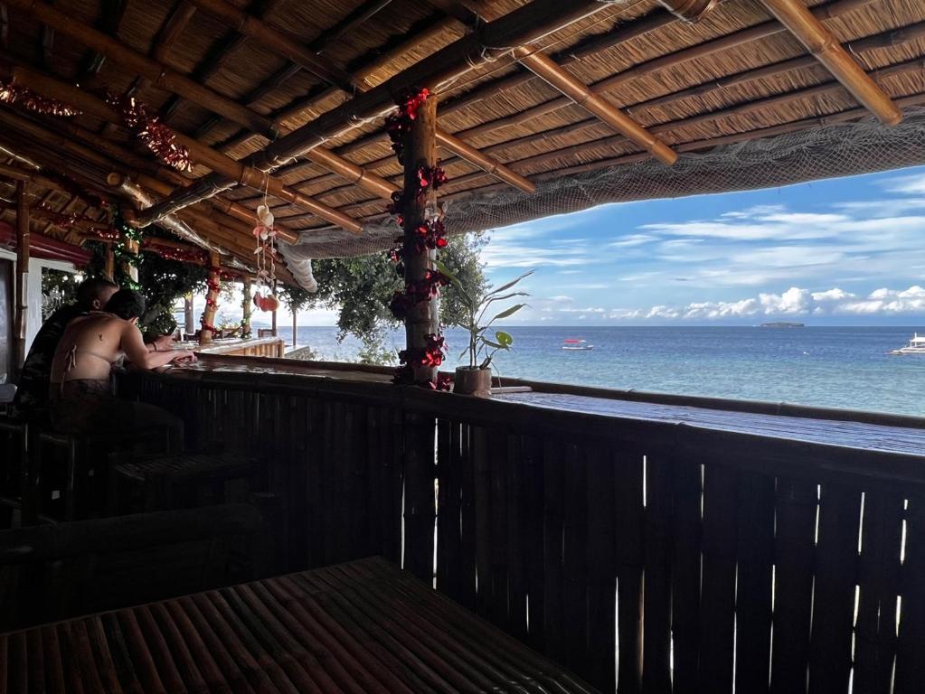 um bar com vista para o oceano em Sunnyside Moalboal Guest house - 써니사이드 모알보알 게스트하우스 em Moalboal