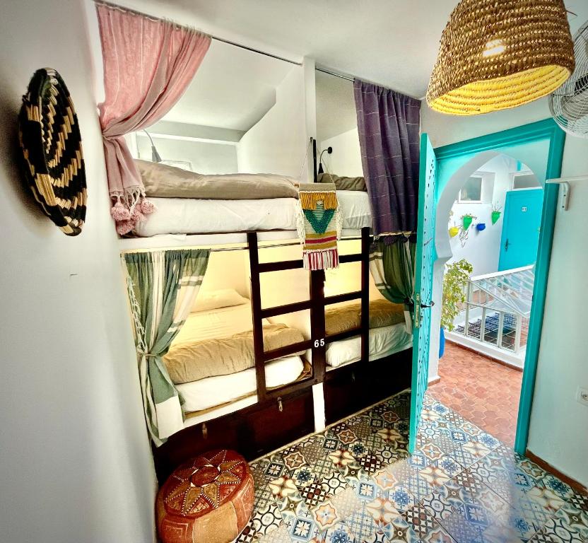 a room with two bunk beds and a room with a mirror at Darna Hostel in Tetouan