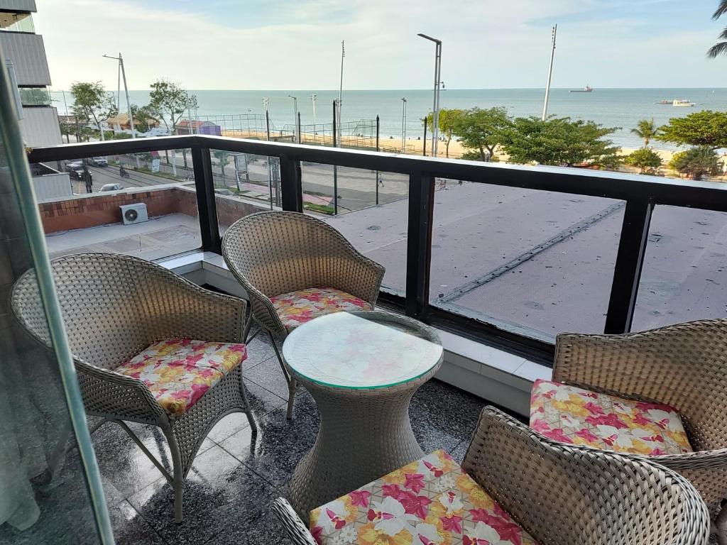 balcón con sillas y mesa y vistas a la playa en Belíssimo frente mar 107, en Fortaleza
