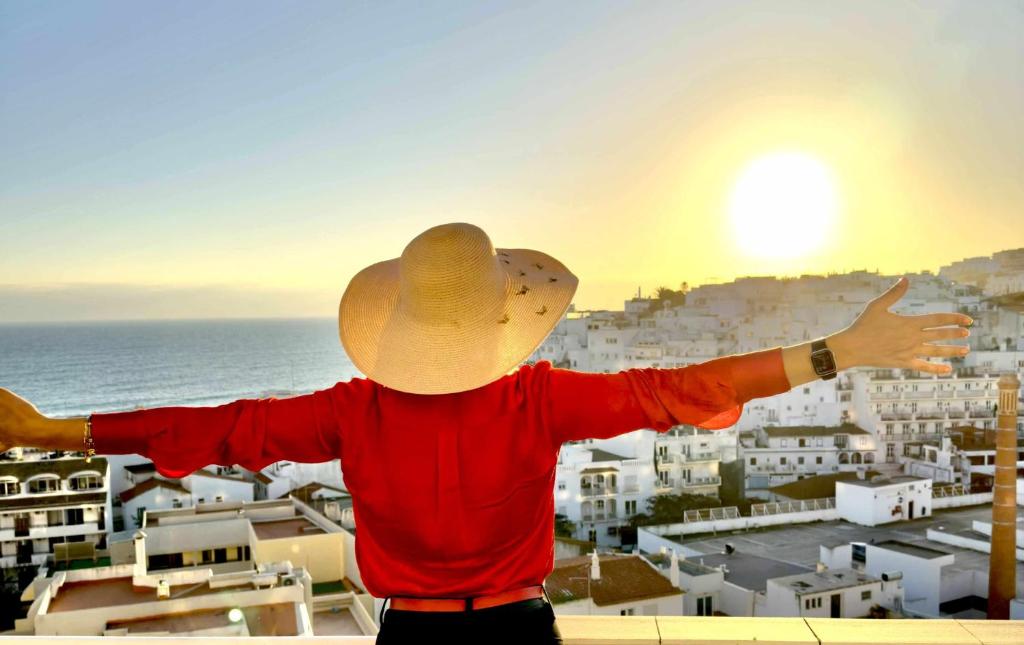 a man wearing a cowboy hat looking at the ocean at Duplex Sea View by Albufeira Holidays in Albufeira