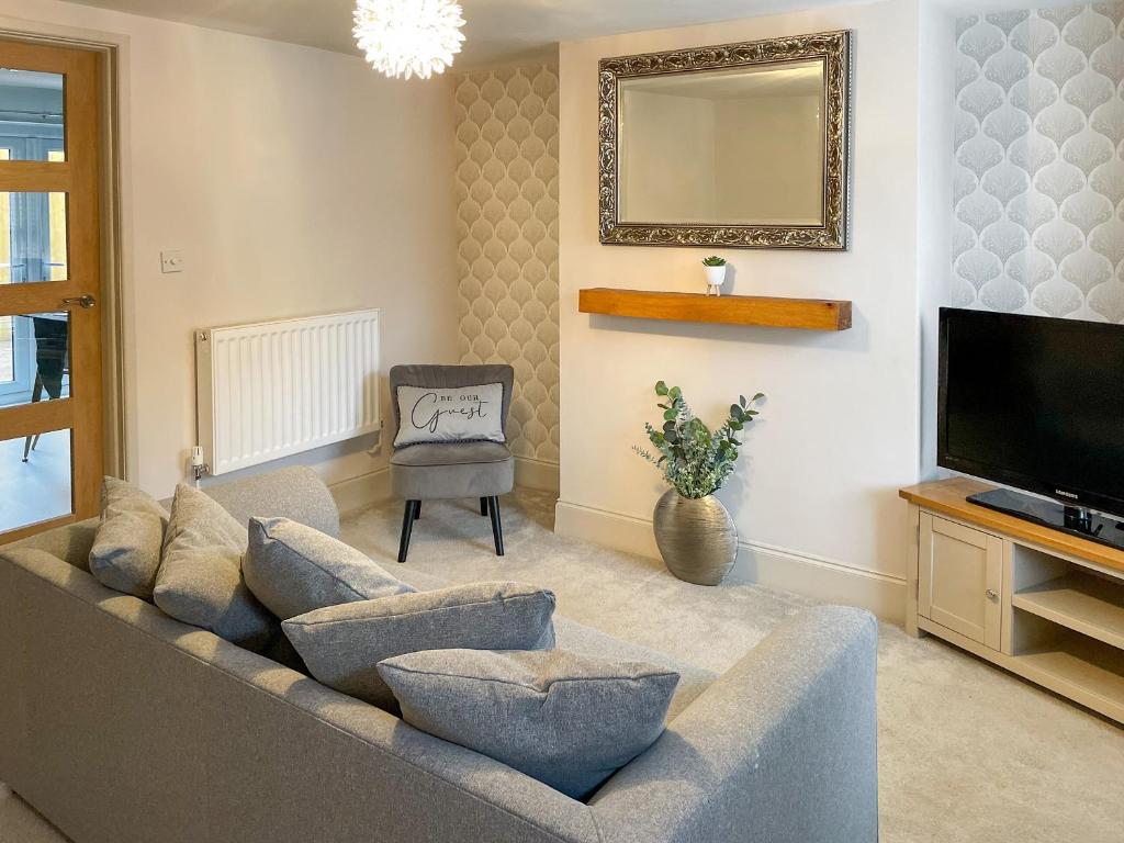 a living room with a couch and a television at Driftwood Cottage in Gorleston-on-Sea