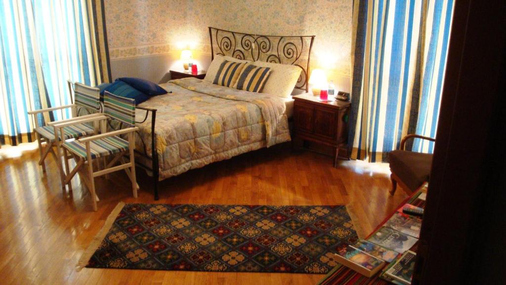 um quarto com uma cama, uma cadeira e um tapete em Il Melograno em Borgo San Dalmazzo