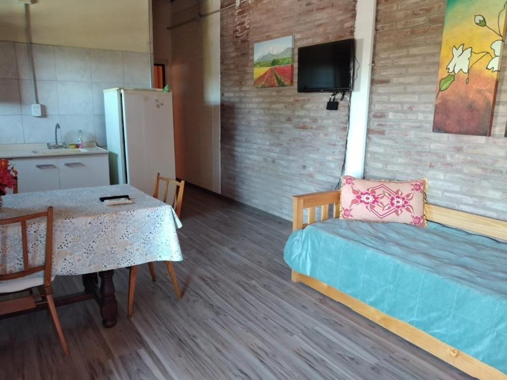 Habitación con mesa, cama y cocina. en Las Violetas en San Rafael