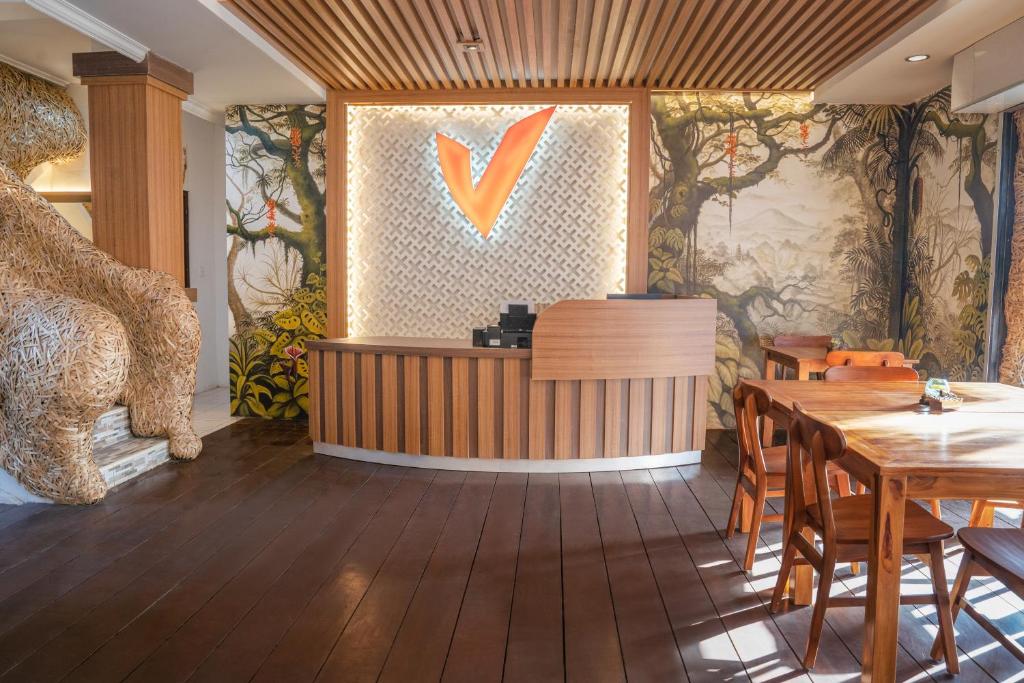 een restaurant met een tafel en stoelen en een v aan de muur bij Vimala Ubud in Ubud