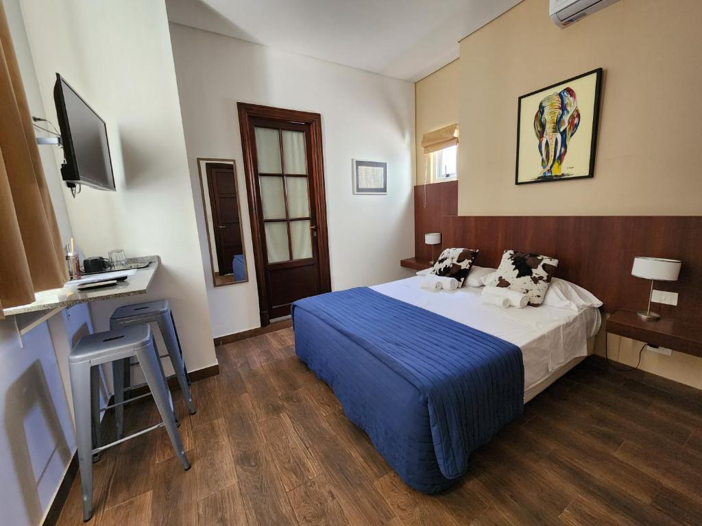 ブエノスアイレスにあるHabitaciones en Suite Balcarceのベッドとデスクが備わるホテルルームです。