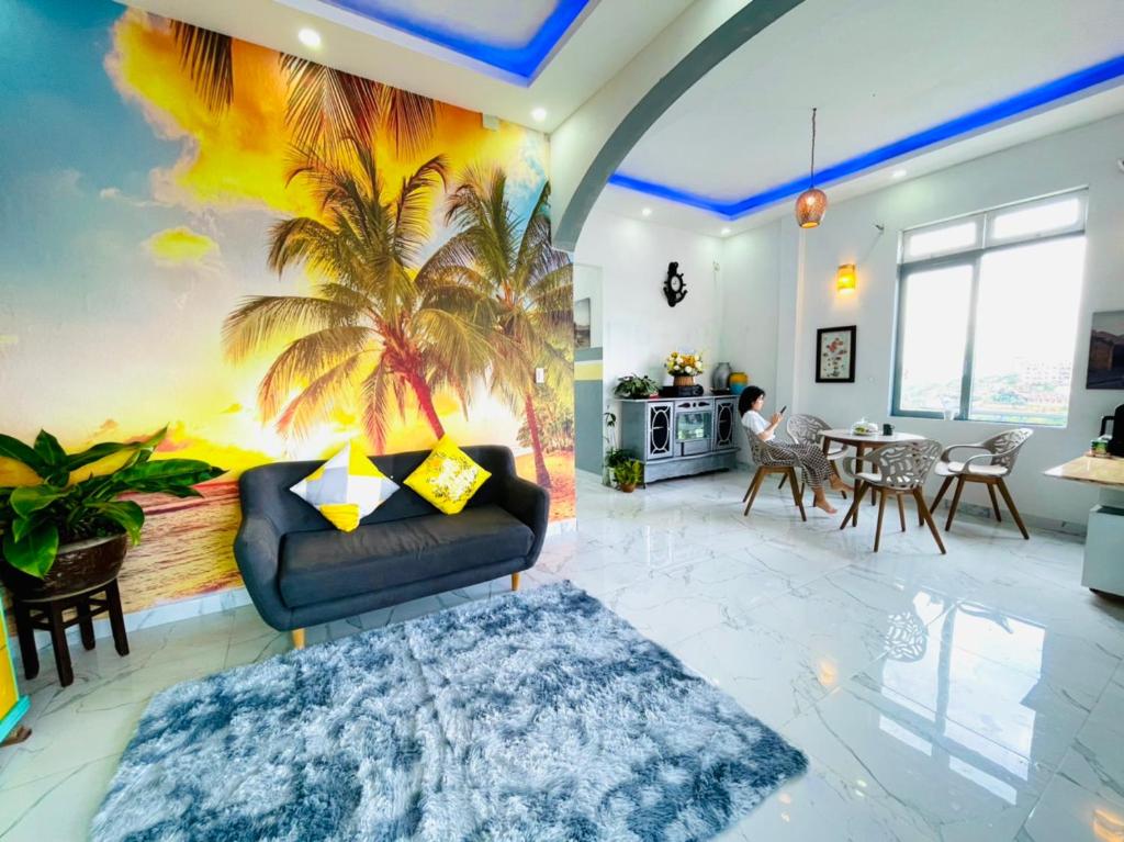 ein Wohnzimmer mit einem Sofa und einem Palmenmilch in der Unterkunft Minh House in Ấp Ða Lợi
