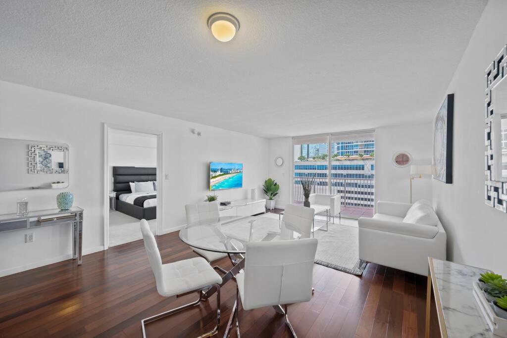 a living room with a glass table and white chairs at Superb unit, centrally located with parking in Miami