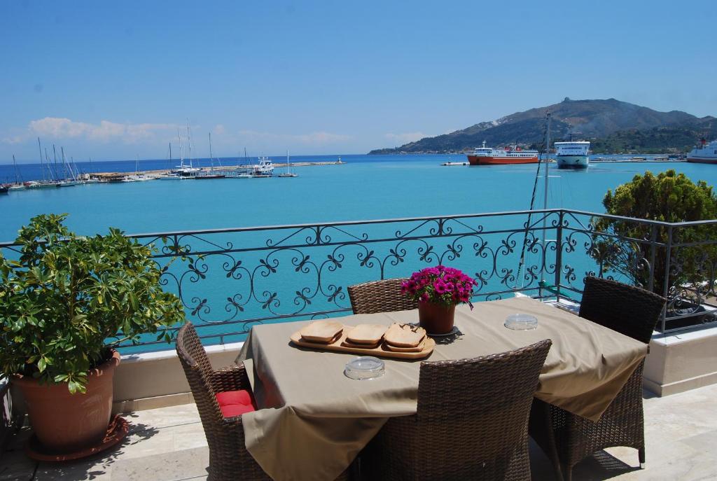 a table on a balcony with a view of the water at Dali in Zakynthos Town