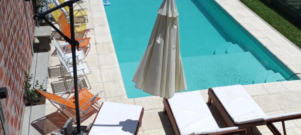 a pool with an umbrella and chairs next to a swimming pool at Jenaz in Federación