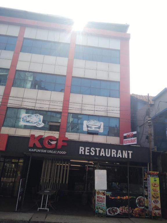 a building with a kfc restaurant sign in front of it at Taj Rest' inn in Kannur