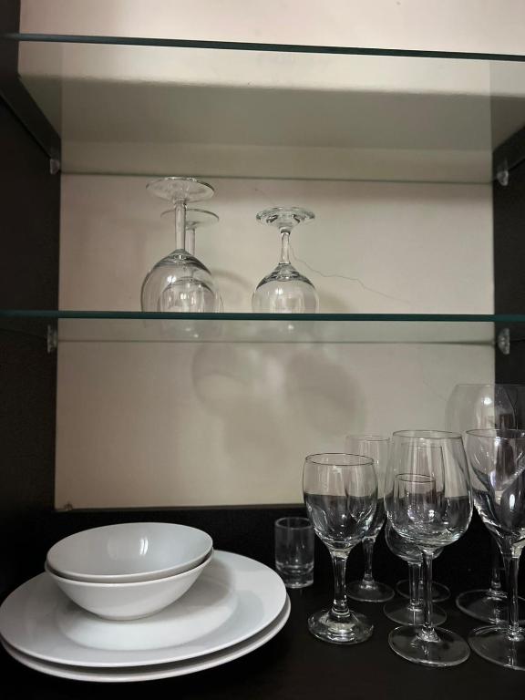 uma mesa com um prato e copos de vinho sobre ele em FernIvy Guest House em Pretoria