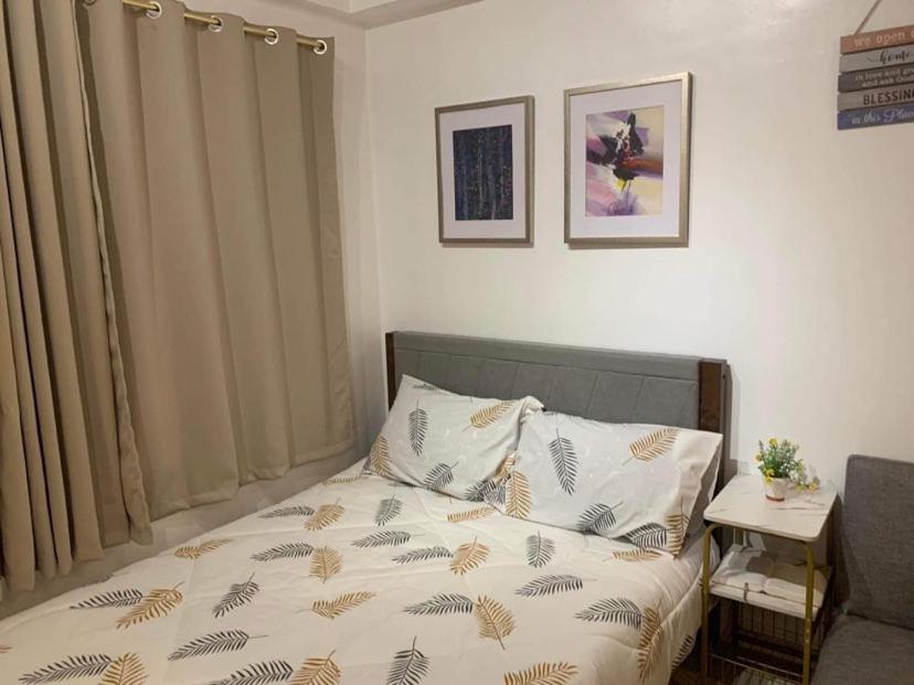 - une petite chambre avec un lit doté d'un couvre-lit avec des feuilles dans l'établissement Comfy Artsy Studio in BGC, à Manille