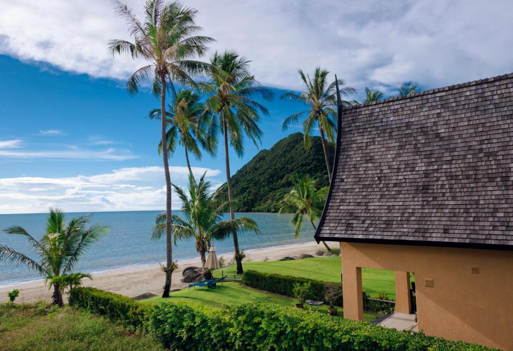 una casa sulla spiaggia con palme e l'oceano di Utalay Koh Chang Villas a Ko Chang