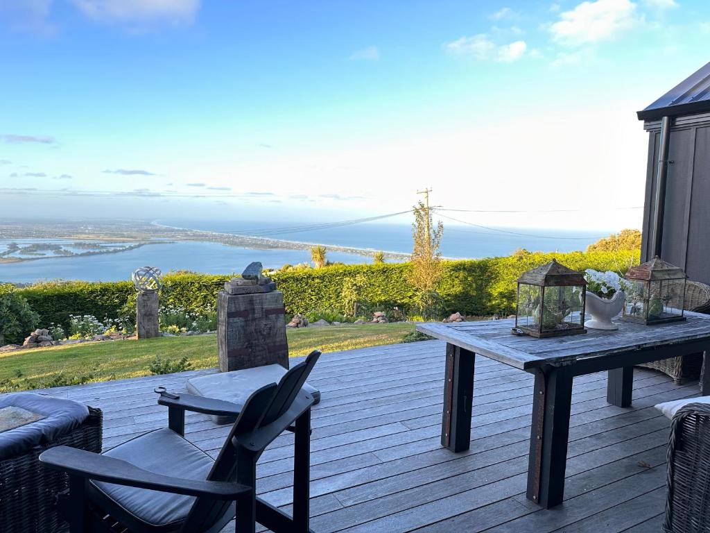 a wooden deck with a table and chairs on it at 340 deg Alps & Sea in Christchurch