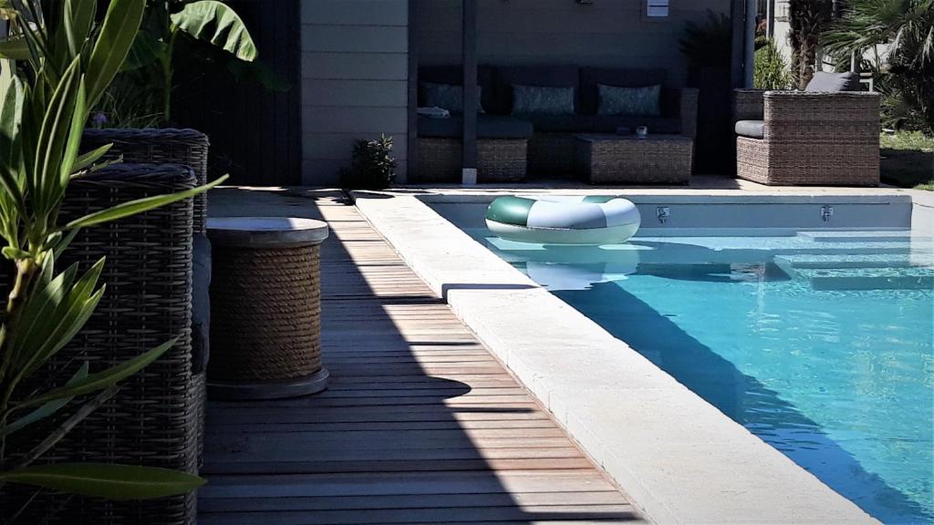 桑特的住宿－勒斯佩斯恩內酒店，一座带木甲板的游泳池,位于一座房子旁边