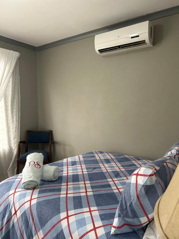 un osito de peluche sentado encima de una cama en Jobe Guesthouse, en Pietermaritzburg