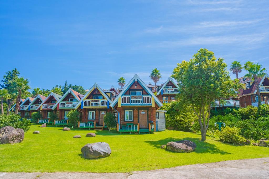 a large house with a yard with rocks at Jungmun Log Pension & Resort in Seogwipo