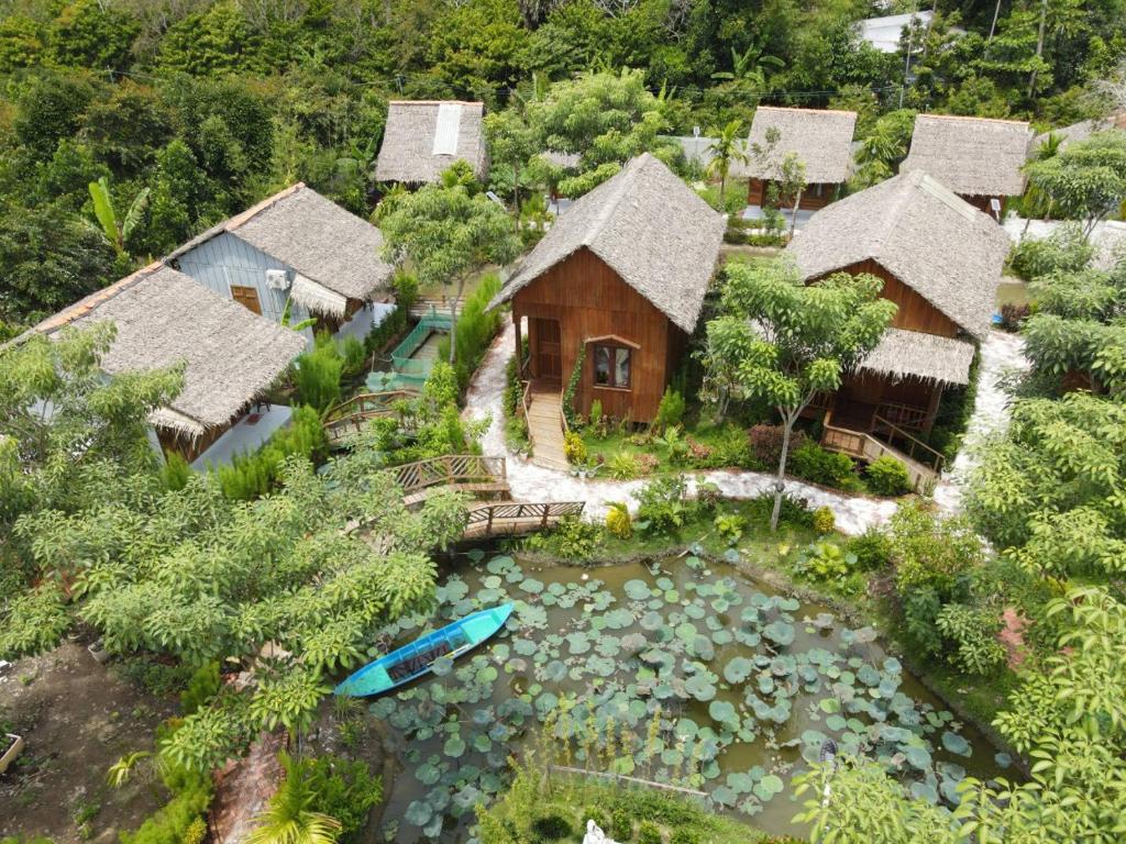 una vista aérea de una casa con un estanque y una casa en Muong Dinh Lodge en Ấp Nhơn Bình