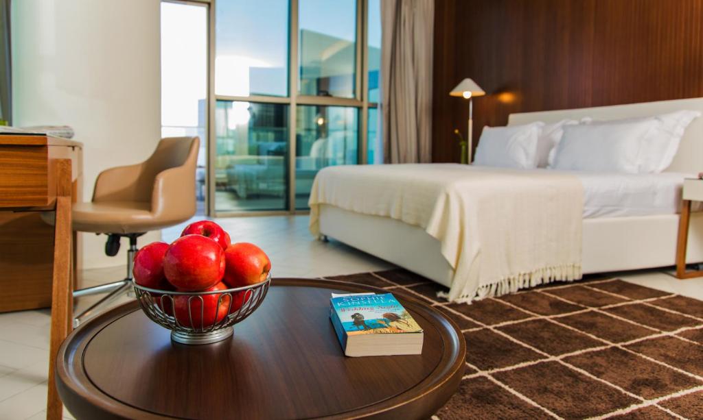 a hotel room with a bowl of fruit on a table at Prima Millennium in Ra‘ananna