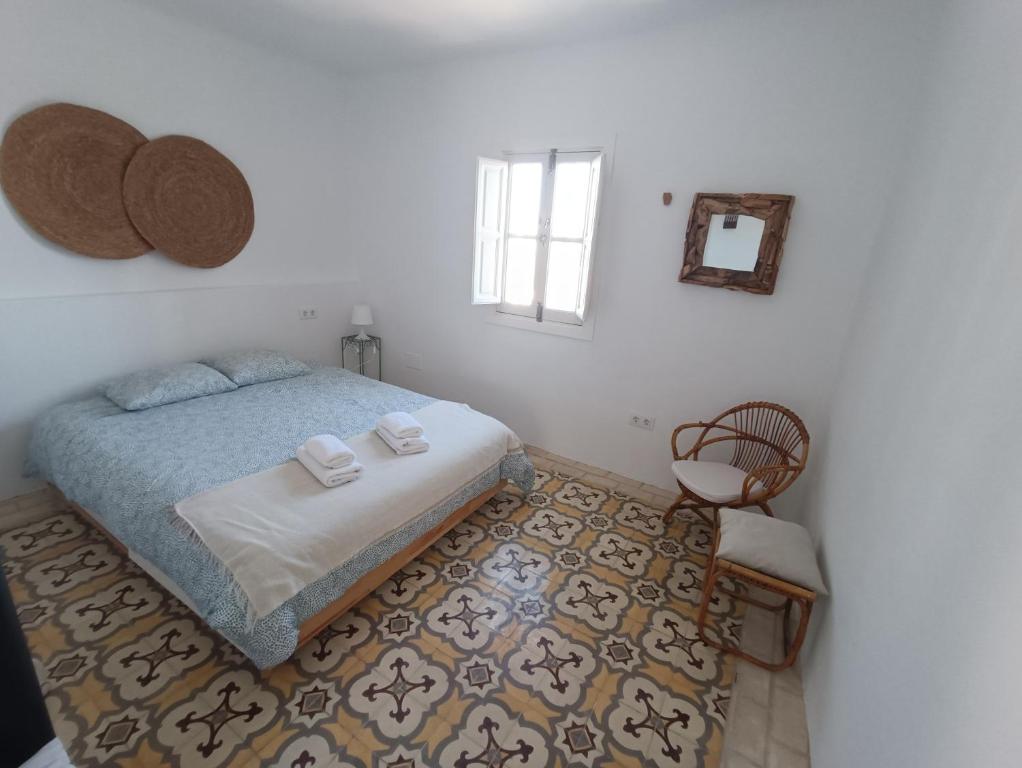 - une chambre avec un lit, une chaise et une fenêtre dans l'établissement Casa Al-Janda, à Barbate