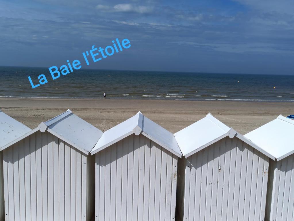 une clôture blanche sur la plage près de l'océan dans l'établissement La Baie L’Etoile, Apt 4 pers, bord de mer, parking privé, Fort Mahon Plage, à Fort-Mahon-Plage