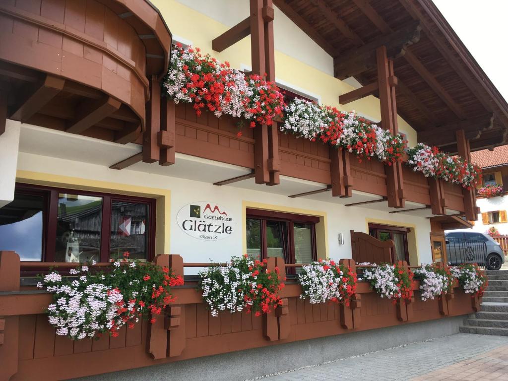 a restaurant with flowers on the side of a building at Glätzle`s Ferienhaus in Zöblen