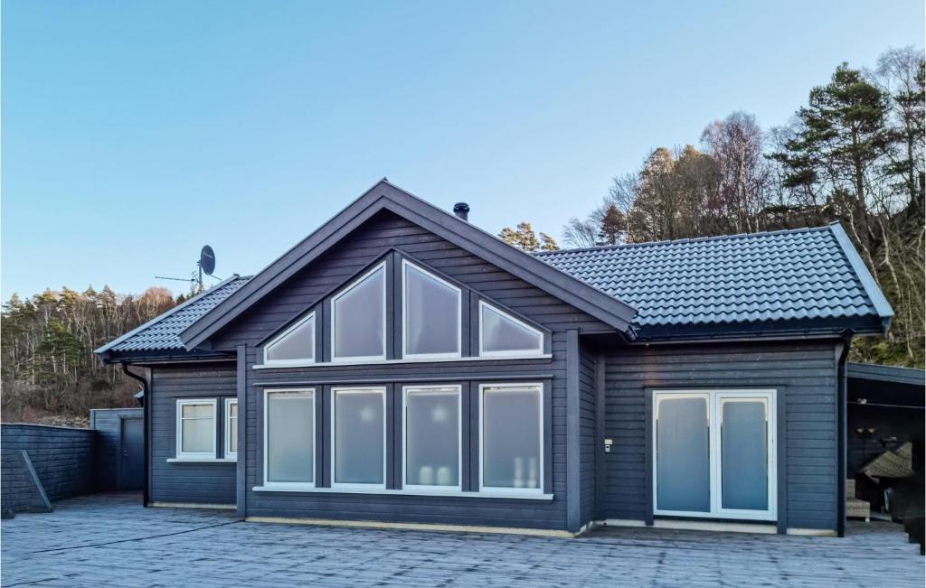 una casa con ventanas grandes en una entrada en Stunning Home In Lyngdal With Kitchen, en Lyngdal