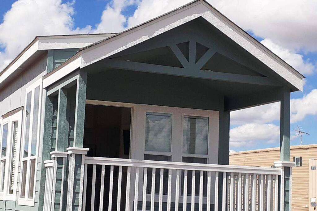 a house with a porch with a white fence at 038 Tiny Home nr Grand Canyon South Rim Sleeps 4 in Valle