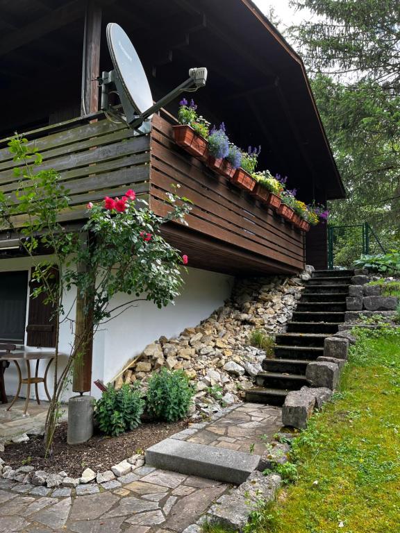 a house with a retaining wall and stairs with flowers at Alb Landhaus in Inneringen-Hettingen