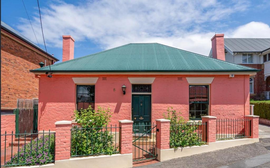 a red brick building with a green roof at Waterloo Cottage in Hobart