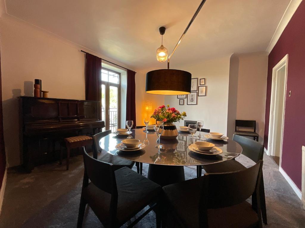 a dining room with a table and a piano at Large 4 double bedroomed townhouse in central Holmfirth in Holmfirth