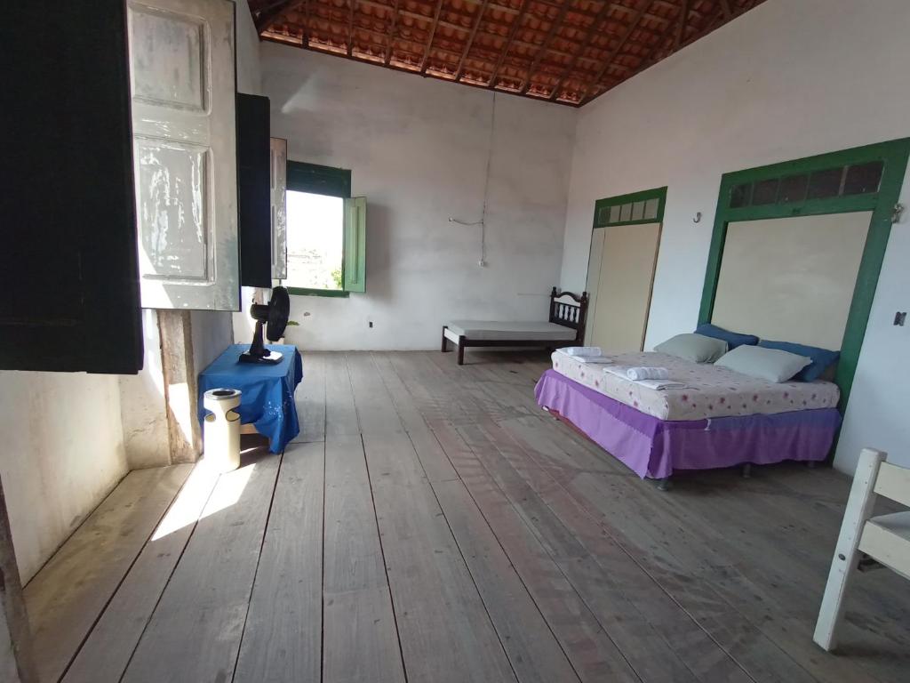 um quarto com uma cama e uma mesa num quarto em Hostel L B em São Luís