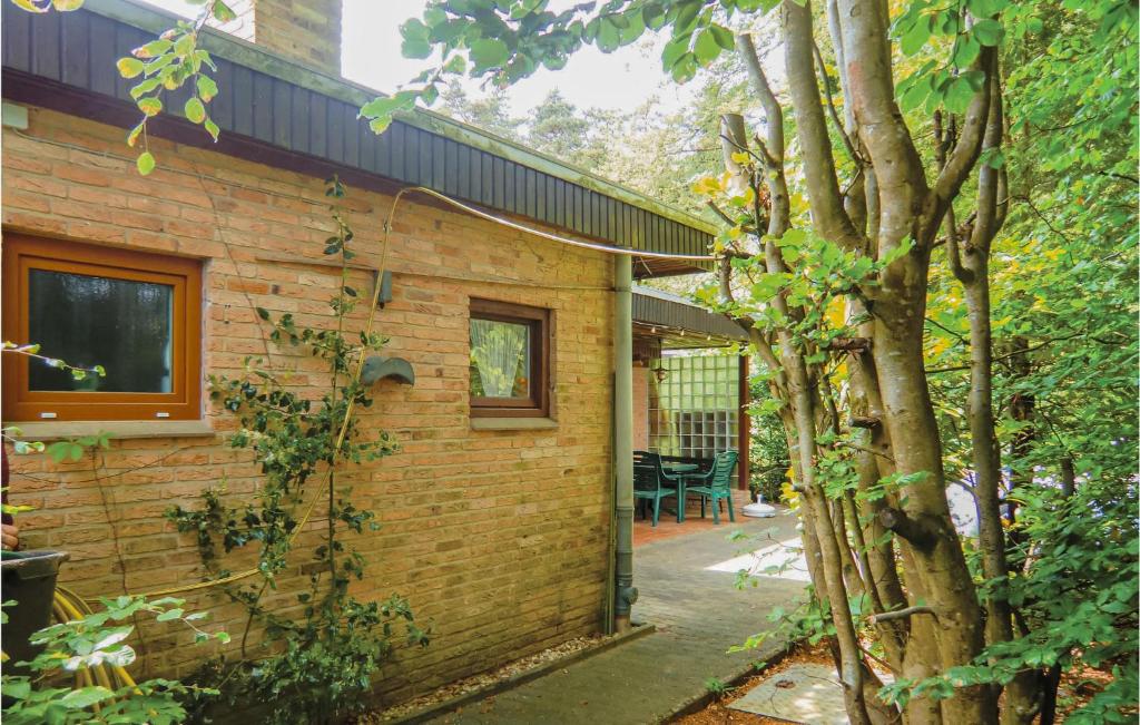 ein Backsteinhaus mit einer Terrasse und einem Baum in der Unterkunft 1 Bedroom Awesome Home In Prmzurlay in Prümzurlay