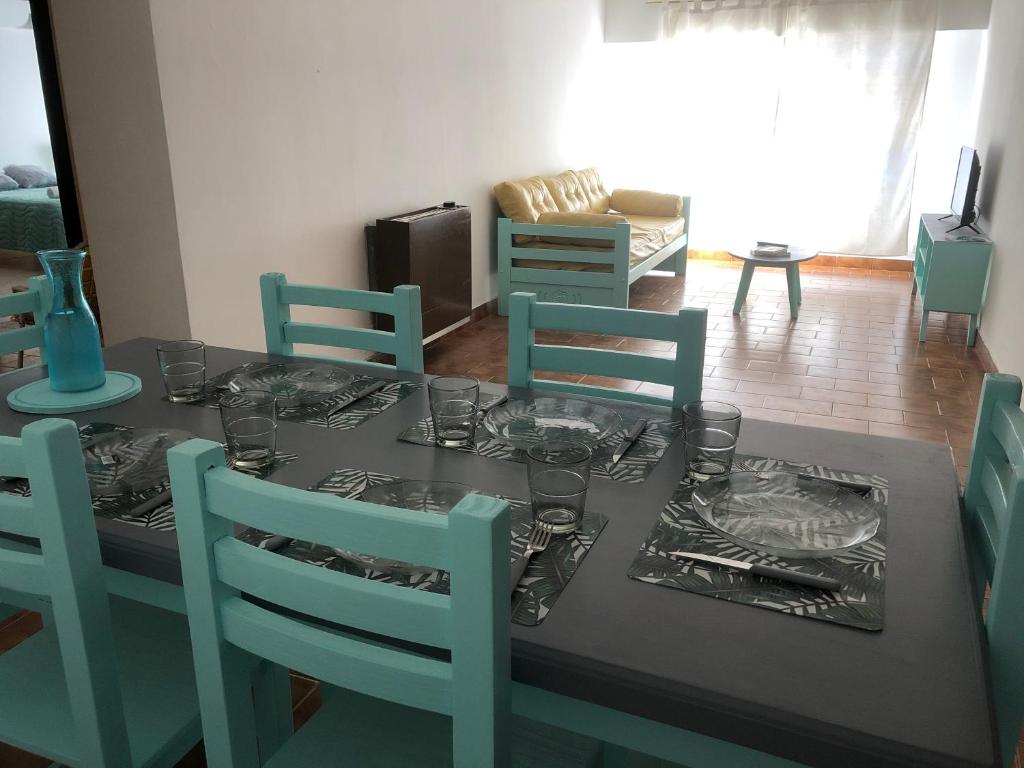 ein Esszimmer mit einem Tisch mit Tellern und Besteck in der Unterkunft AQUA in Puerto Madryn