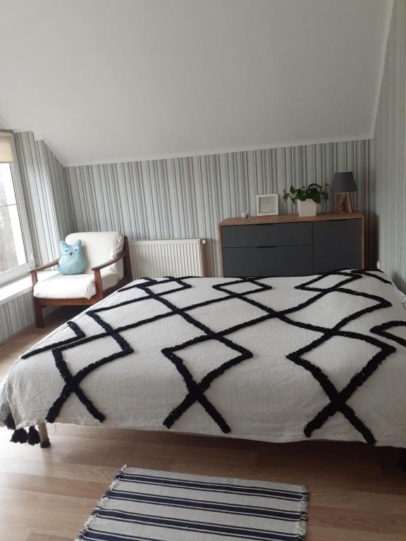 a bedroom with a black and white bed and a chair at Homestay Khomenko in Perechin