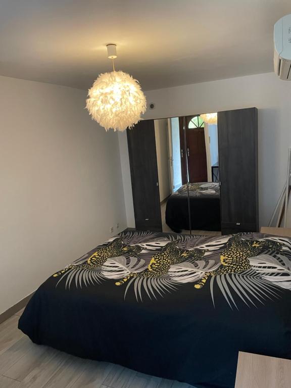 - une chambre avec un lit et un grand miroir dans l'établissement Chez Tikaf, à Saint-Claude