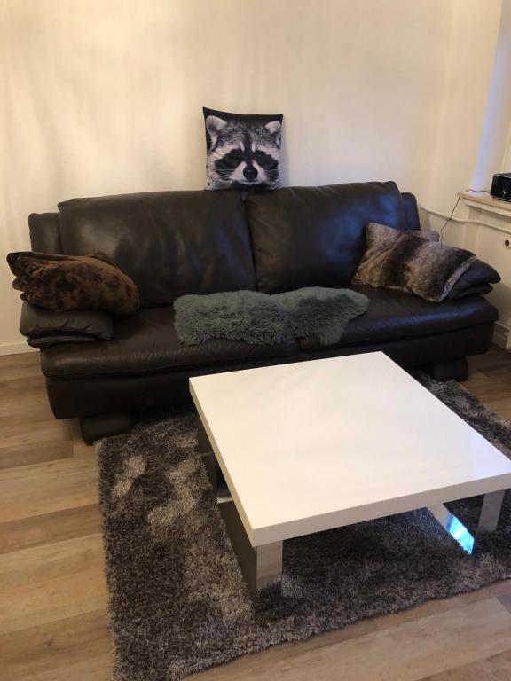 a black leather couch with a white coffee table at Ferienwohnung Waschbärglück in Hahnenklee-Bockswiese