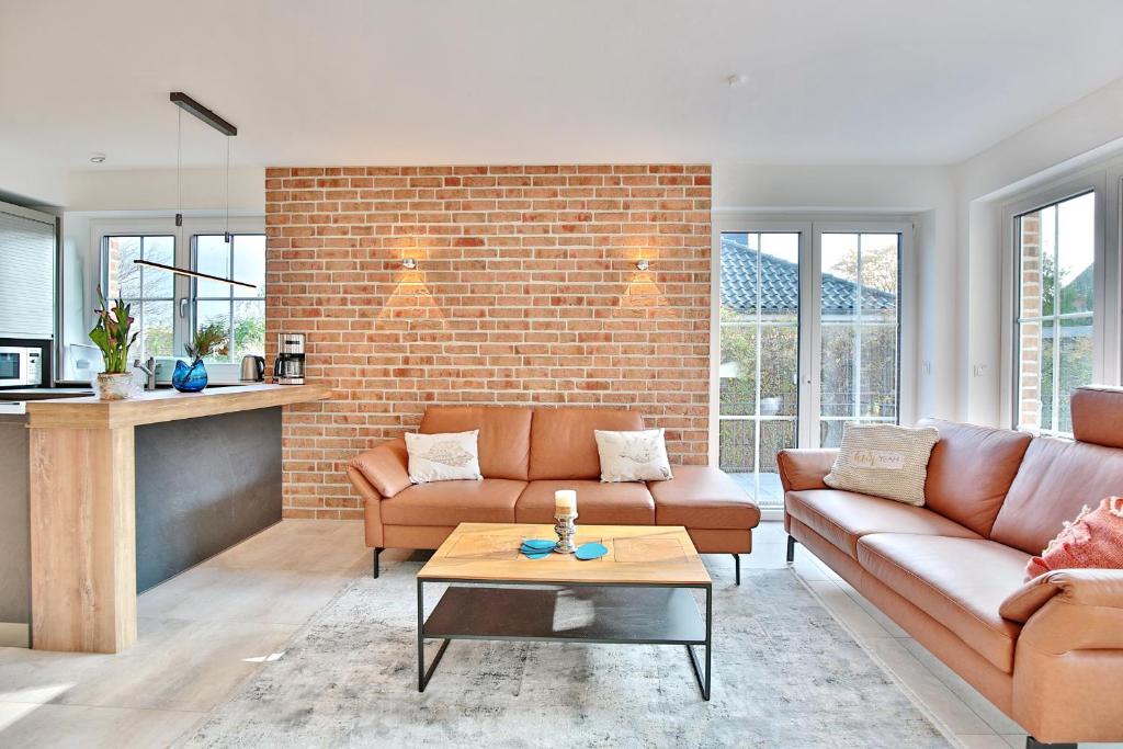 a living room with two couches and a brick wall at Haus Oberdeck 1 in Scharbeutz