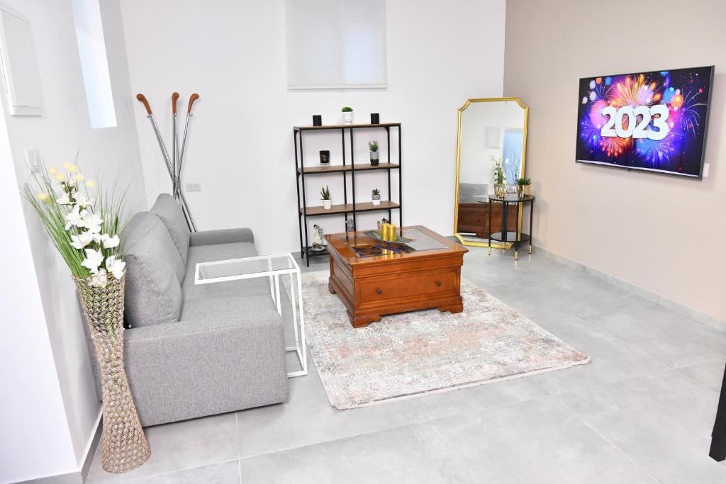 a living room with a couch and a coffee table at Deluxe Basement Apartment Bahai's Garden in Haifa