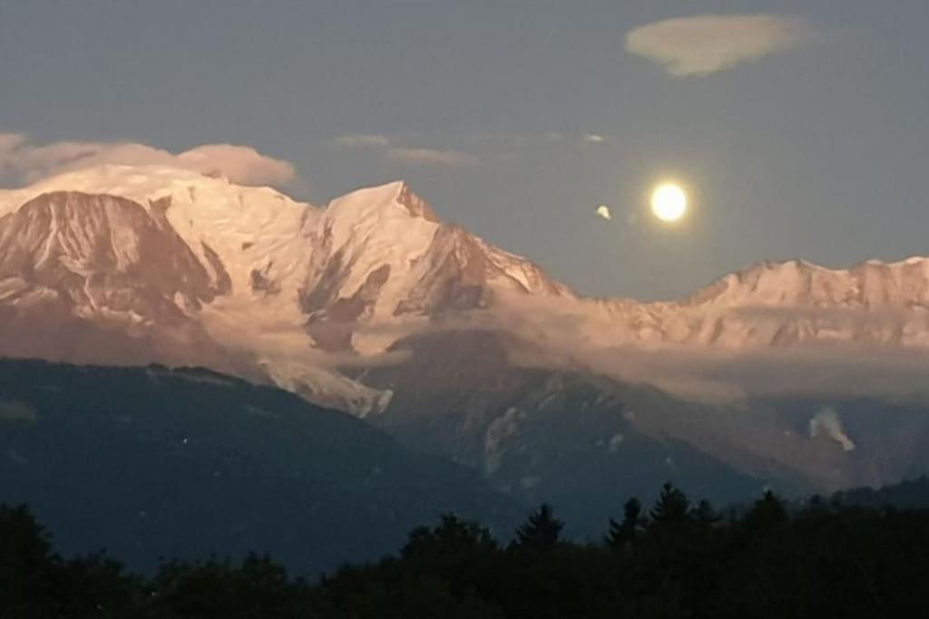 a snow covered mountain with the moon in the sky at Sweety home- Vue Mt-Blanc - A 15 min de pistes de ski in Sallanches