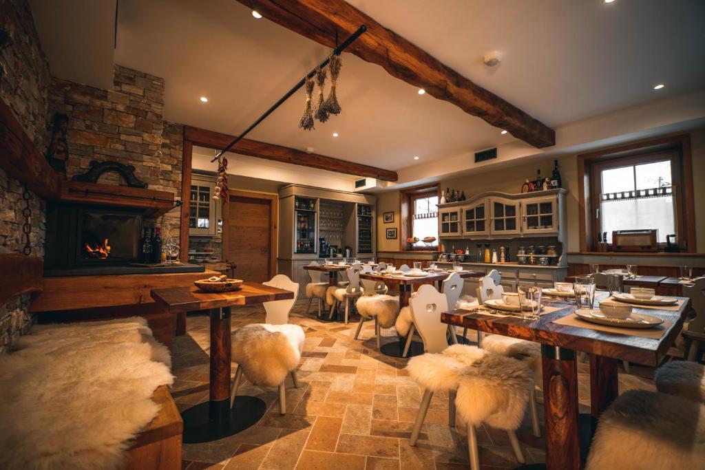 a dining room with tables and chairs and a fireplace at Hotel Zamorc in Škofja Loka