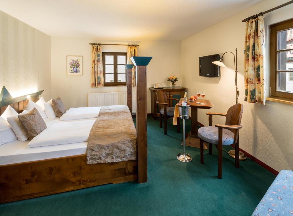 Cette chambre comprend un lit, un bureau et une chaise. dans l'établissement Hotel Saigerhütte, à Olbernhau