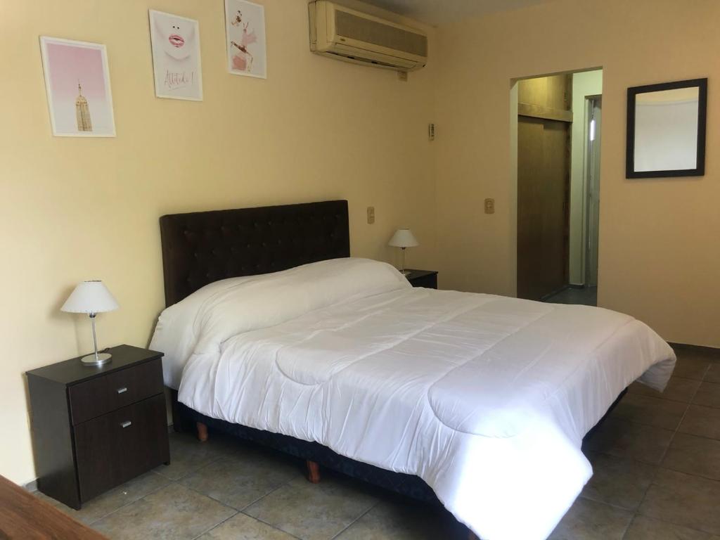 1 dormitorio con 1 cama blanca grande y mesita de noche en Escápate a Mendoza !! Apartamento SAN MARTIN en Godoy Cruz