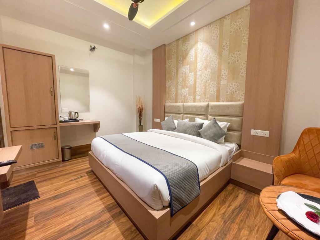 Schlafzimmer mit einem Bett, einem Schreibtisch und einem Stuhl in der Unterkunft Hotel Crown Savoy, Near Railway Station & GURU NANAK DEV UNIVERSITY in Amritsar